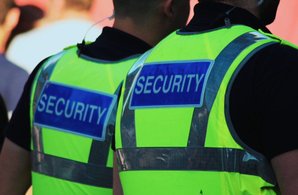 two security guards wearing reflective yellow vests